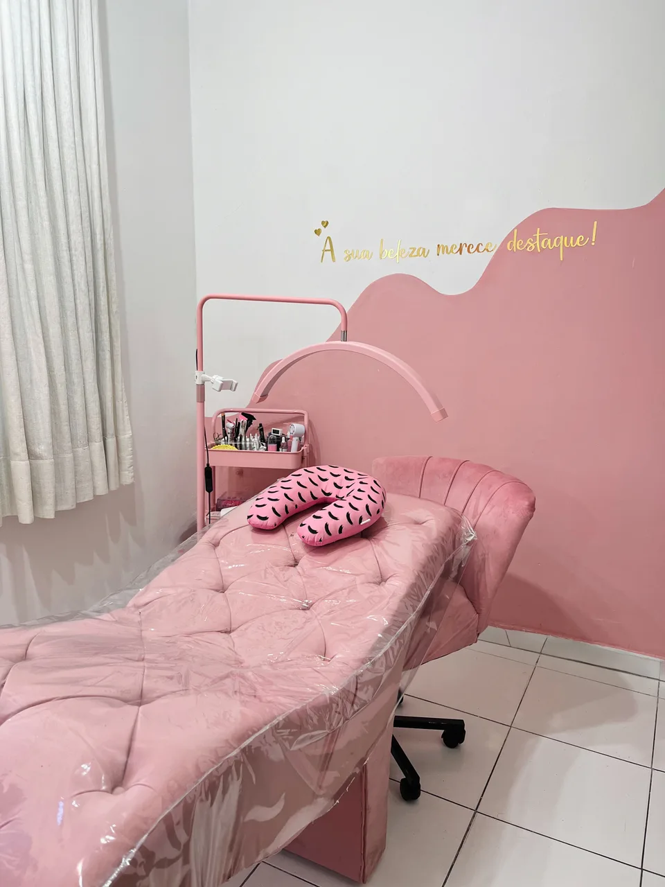 Espaço da Giovana com maca rosa e iluminação de atendimento